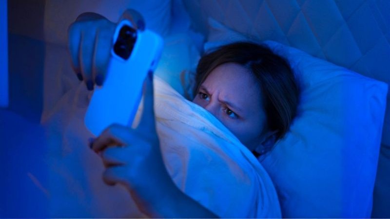 Žena s mobilem v posteli - věčně online